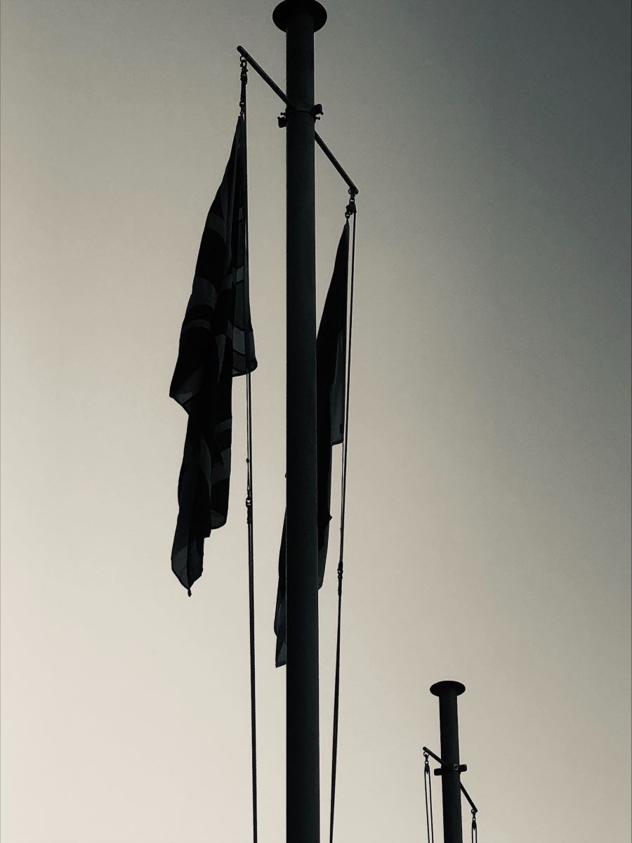 black and white photo of two flags on a flagpole